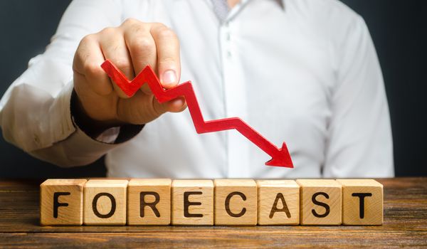 Man holds red arrow down over word Forecast. A budget shortage, recession economy, unprofitable company. Prediction of profit fall, value of assets and market conditions. reduction income and earnings
