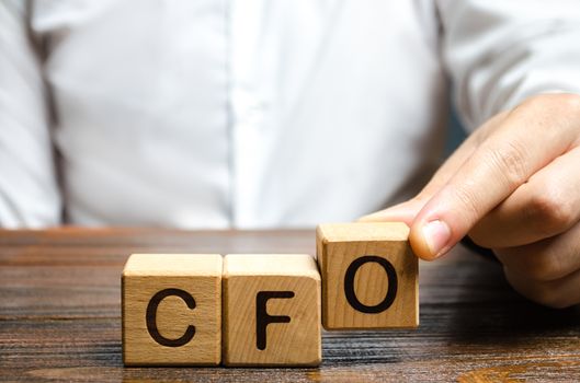 A man makes the word acronym abbreviation CFO. Chief Financial Officer. Financial management in business and company. Risk. Development and growth. Appointment to a new post, promotion.
