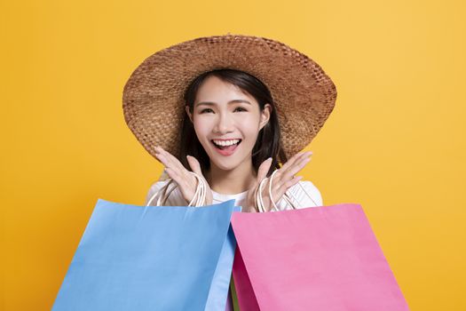 young woman in summer hat and holding shopping bags