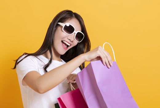surprised young woman in sunglasses and watching the shopping bags