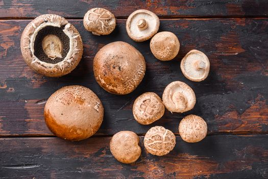 Shiitake and portobello mushrooms set on old wooden table, top view space for text.