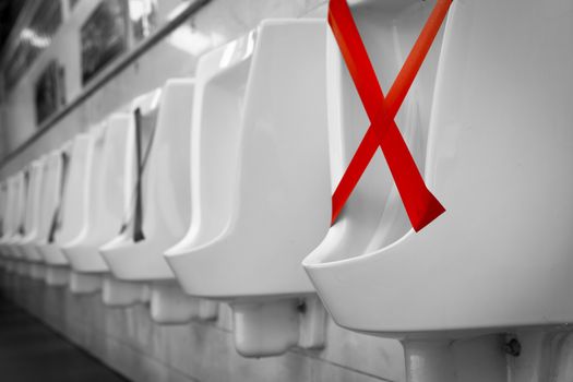 White ceramic urinals in men public toilet. Social distancing in