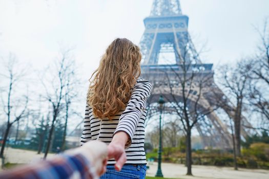 Beautiful girl near the Eiffel tower, follow me concept