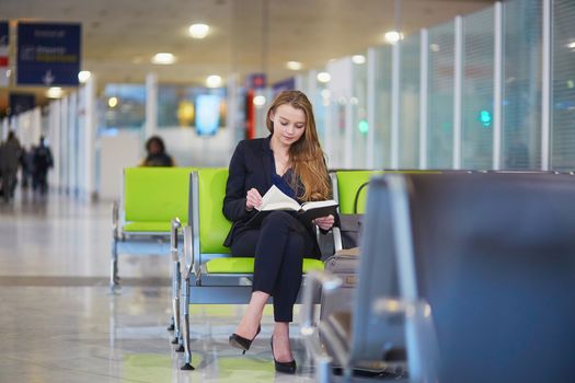 Business woman reading a book in international airport