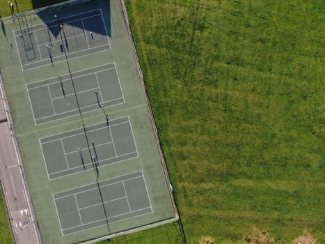 aerial view of parkland showing tennis courts in evening sunshine