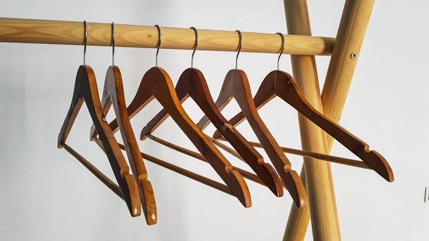 Wooden hangers weigh without clothes on a wooden frame.
