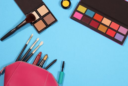 Cosmetics and Brushes on blue paper background