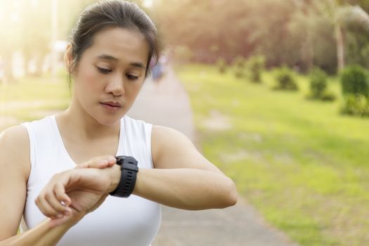 Asian Woman setting up the fitness smart watch for running. youn