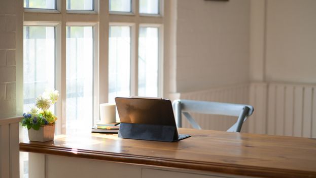 Laptop with a notebook and coffee on a wooden table in the offic
