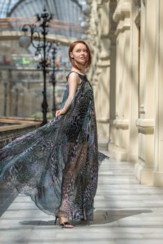 Happy young woman in a fashionable flutter transparent cape