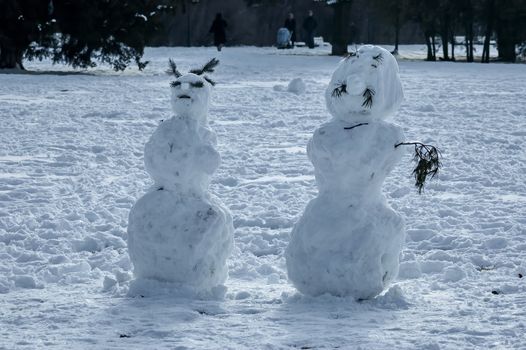 Winter scene with a snowman made with handy materials in the park