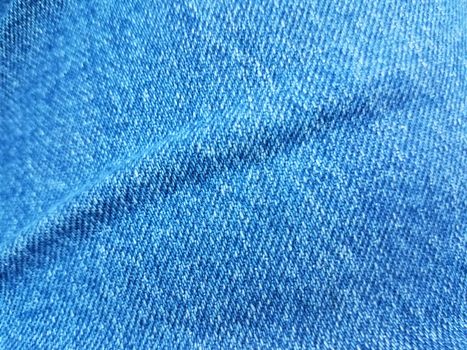 blue denim jean fabric or textile with a crease