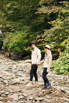 Young couple at the Carpathian - Happy tourists visiting mountains. Lovestory. Tourists in hats. Military fashion