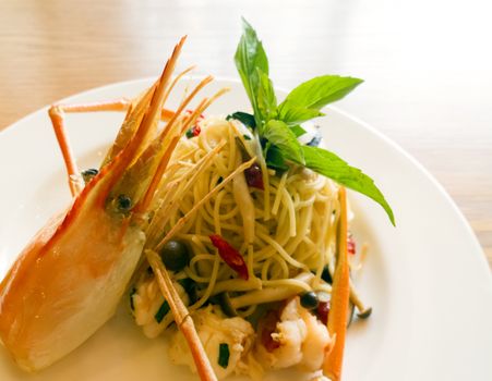 italian spaghetti pasta and fresh spicy shrimps sauce on wooden table