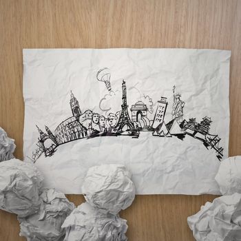 crumpled paper with hand drawn traveling around the world on woo
