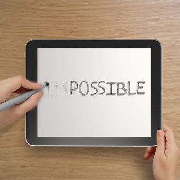 hand changing the word impossible to possible with stylus eraser