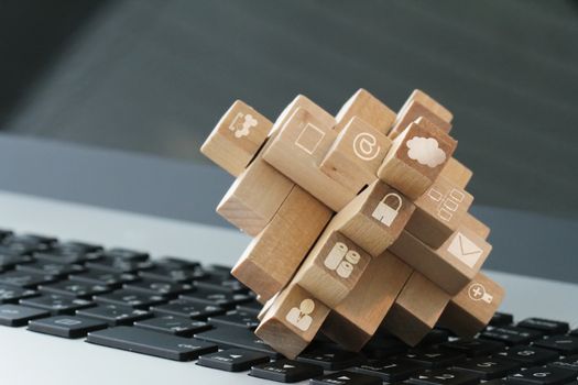 wooden cubes with technology icons on computer as cloud network 