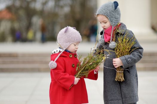 Two sisters holding willow branches on Easter