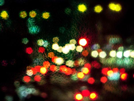 raindrop on glass and blur traffic jam