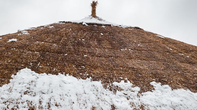 roof made from straw with snow on it