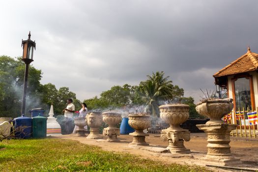 COLOMBO, SRI LANKA - DEC 11: An unidentified Buddhist devotee burn incense sticks as a religious ritual at the Kelaniya Raja Maha Vihara on December 11, 2013 in Colombo, Sri Lanka.