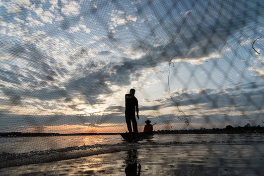 Silhouette of Fishermen throwing net fishing in sunset time at W