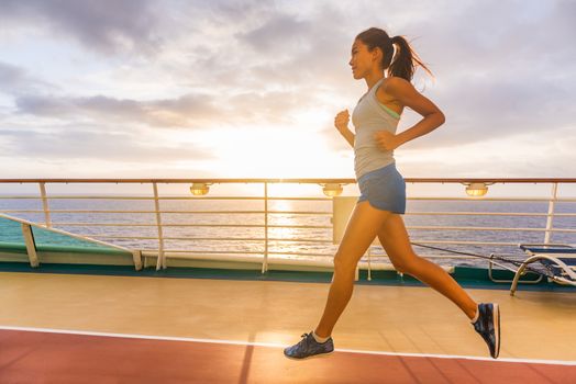 Cruise ship passenger doing morning jogging on deck running tracks with sunrise sunshine. Woman tourist enjoying fitness training during Caribbean travel vacation.