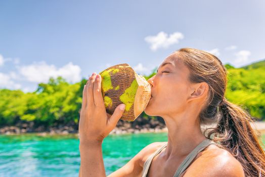 Coconut water Caribbean tropical food tourist woman drinking fresh natural from the coco on cruise ship travel vacation. Asian girl enjoying summer holidays.