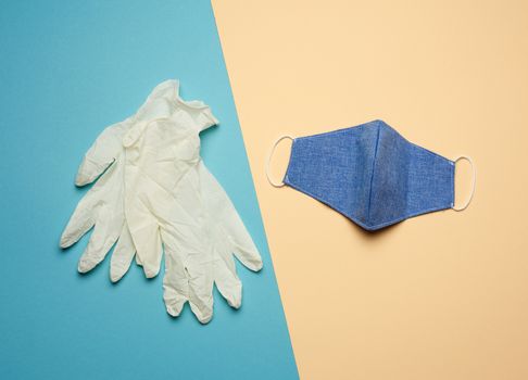 white latex gloves and blue reusable textile mask on a blue beig