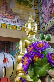 Golden Buddha statue and offerings at Gangaramaya Temple