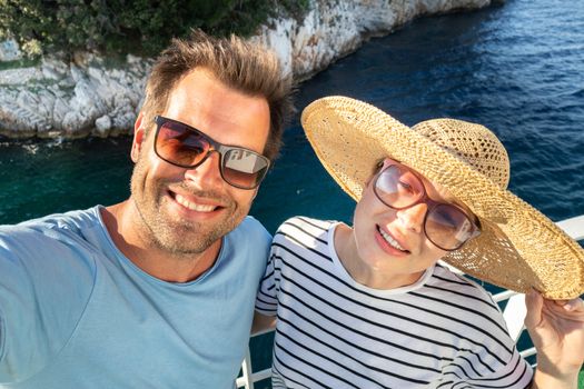 Beautiful, romantic caucasian couple taking selfie self portrait photo on summer vacations traveling by cruse ship ferry boat.