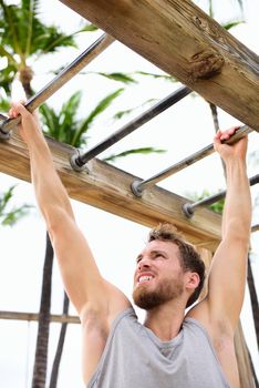 Workout man working out arms on brachiation ladder