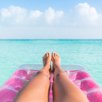 Summer holiday girl tanning legs relaxing in ocean