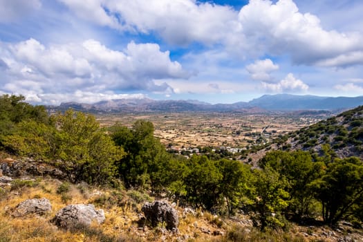 Top view of the Lassithi Plateau on a sunny clear day with a cloudy sky in the background. Crete island.