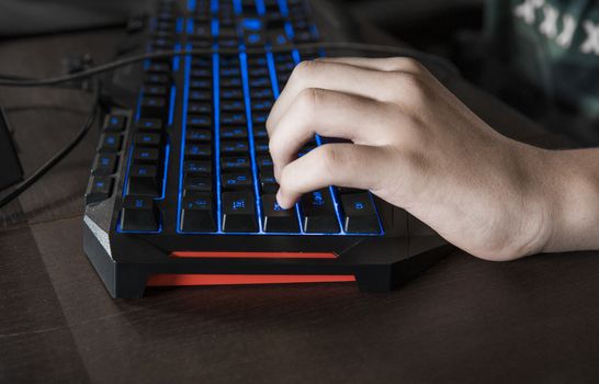 Gamer keyboard with colorful blue lights, modern gamer computer. Blue backlight, backlit on laptop or keyborad computer of gaming.