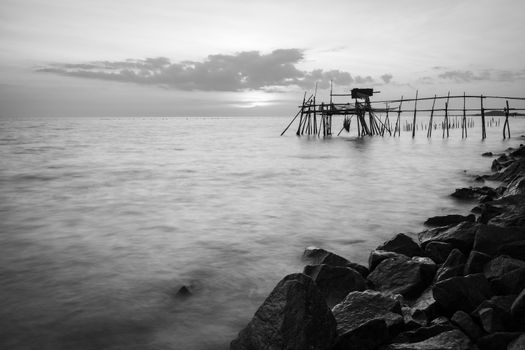 Wooden fisherman's hut in the Malacca strait during sunset. Landscape orientation. Black and white.