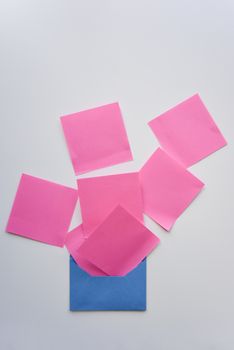 selective focus, pink paper stickers in chaos and blue envelope 