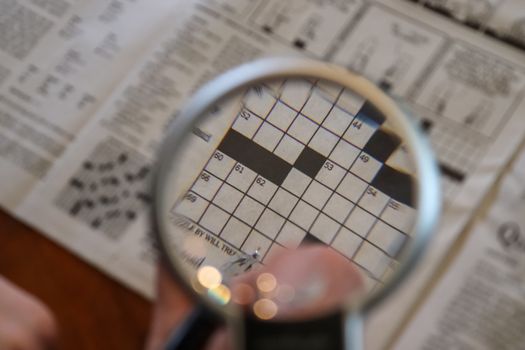 Close up view on international newspapers with a magnifying glas
