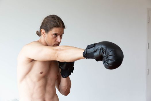 A sport man has boxing training in his living room at home