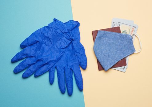 blue latex gloves and blue reusable textile mask on a beige back