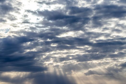 Sun rays breaking through cumulus clouds. The concept of divine light, a glimmer of hope or overcoming difficulties. Spiritual religious background.
