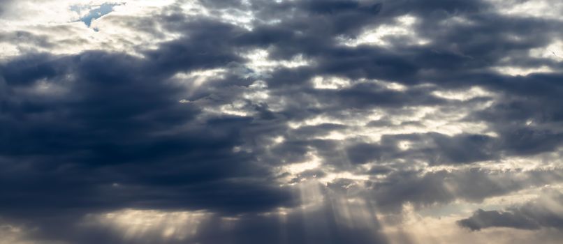 Sun rays breaking through cumulus clouds. The concept of divine light, a glimmer of hope or overcoming difficulties. Spiritual religious background.