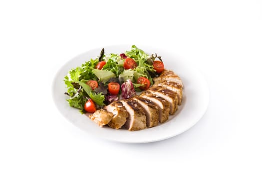 Grilled chicken breast with vegetables on a plate isolated on white background