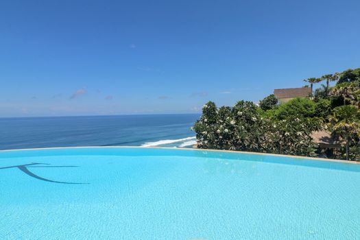 Luxury infinity pool with sea views and palm trees. Bali, Indonesia