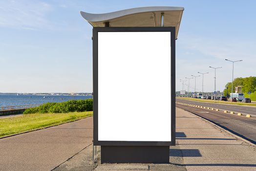 glass bus stop by the sea, with a white advertising space. Blank billboard and outdoor advertising. Mockup poster outside. Tallinn, Estonia.