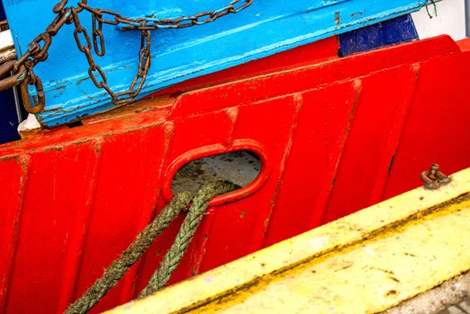 Mooring line of a trawler on a red ship hull