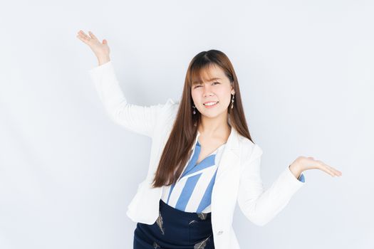 Smiling Asian business woman pointing hand to side blank space over grey background. Back to the normal concept.