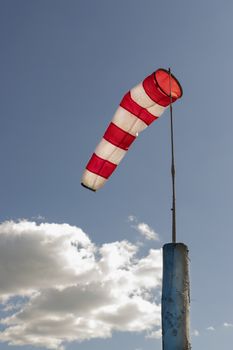 Windsock against cloudy sky