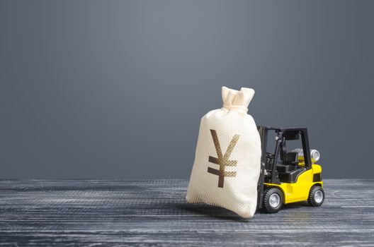 Yellow forklift carries a Yen yuan money bag. Big contract, profitable deposit, take a loan. Payment of taxes. Inflation, price increases. Wealth, big investments in economy. Grants, project financing