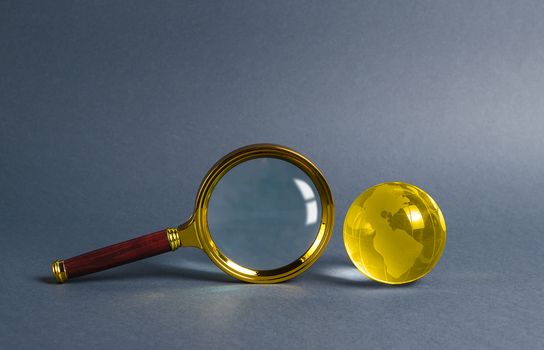Magnifying glass and planet earth glass ball. Concept of global search and globalization process. International business and logistics. Search engine, exploration of the world. Border transparency.